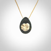 A hand carved baby in the womb pendant made from a jade and bone. This is a work of art carved in jade and bone. We deliver this pendant to you on a plaited cord. Delivery with Express Courier is included in the price.